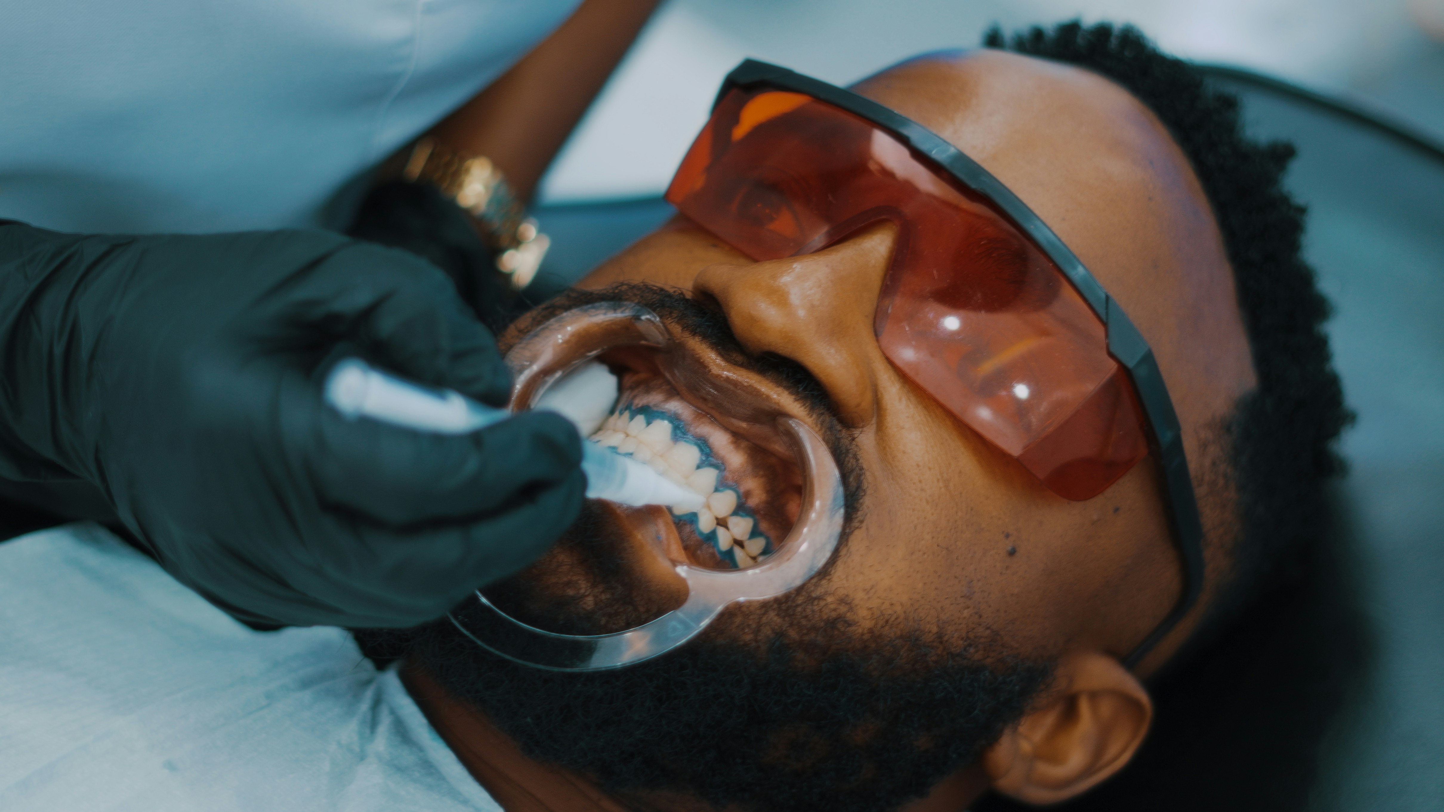 A patient receiving professional teeth whitening treatment